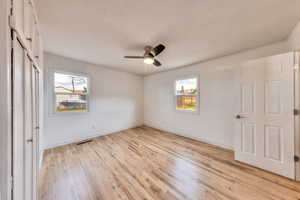 Primary bedroom featuring hardwood floors, a closet, and ceiling fan