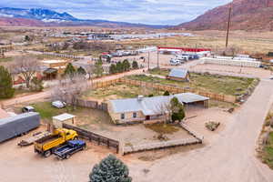 Aerial view of property and surrounding area featuring a mountainous background