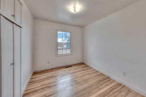 Unfurnished bedroom featuring a closet and hardwood floors