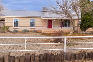 Single story home with a metal roof, a porch, and brick siding