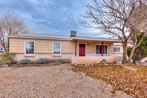 Front of home with a metal roof, a porch, and brick siding