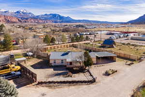 Aerial view of property and surrounding area with a mountain backdrop