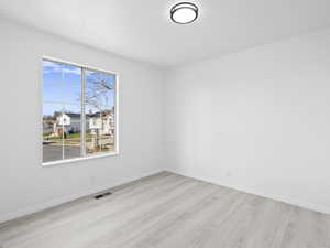 Unfurnished room featuring light wood-style floors and a residential view
