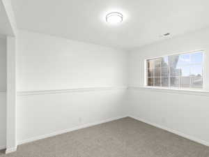 Empty room featuring carpet flooring and baseboards
