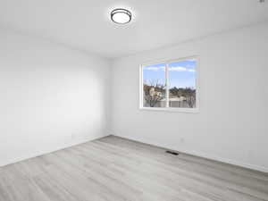 Unfurnished room with light wood-style flooring and baseboards