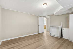 MIL - Bedroom #3 featuring light wood-style flooring and baseboards