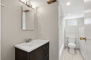 MIL - Bathroom with vanity, recessed lighting, tile walls, shower / bathtub combination with curtain, and light tile patterned floors
