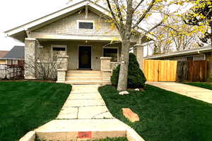 Bungalow-style house with a porch and brick siding.  Fenced Yard.