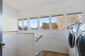 Laundry area with washer and dryer, dark wood-type flooring, and ornamental molding
