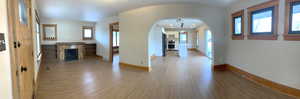 Hall featuring arched walkways, light wood-type flooring, and plenty of natural light with Fireplace.
