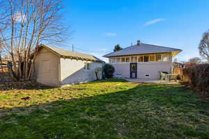 Back of house featuring an garage, a laundry room, and a patio