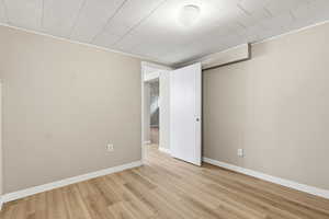 Bonus room (office, workout room, craft room) with baseboards and light wood-style flooring