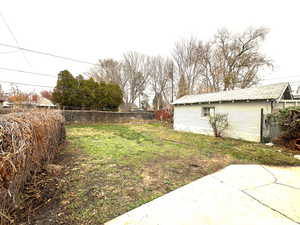 View of very large fenced backyard with detached garage