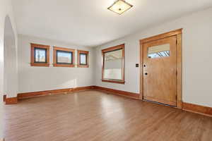 Entryway (living room) with plenty of natural light, light wood-style flooring, and arched walkways