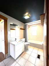 Full bathroom featuring shower / bath combo, vanity, and light tile patterned floors
