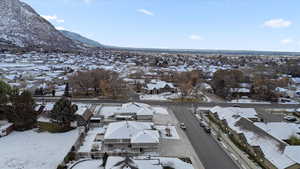 Snowy aerial view featuring a residential view and a mountain view