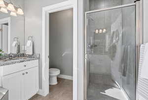 Primary Bathroom featuring vanity, a stall shower, and light tile patterned floors
