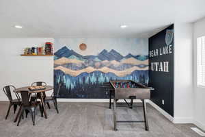 Rec room with an accent wall, carpet floors, a textured ceiling, and recessed lighting