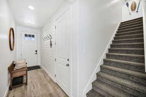 Foyer entrance featuring light wood-style flooring, stairs, and recessed lighting