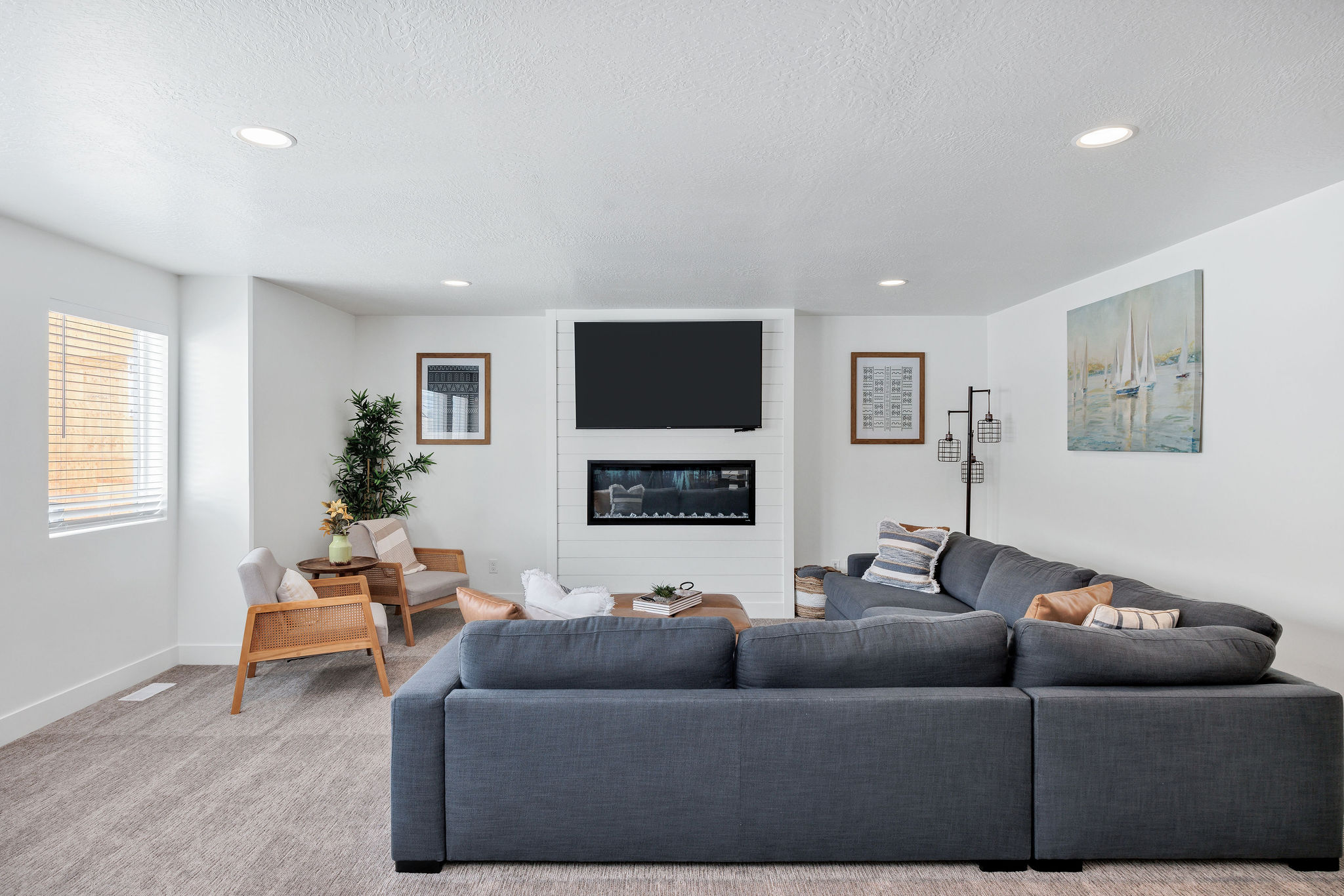 Carpeted living area with a textured ceiling, a fireplace, and recessed lighting