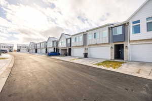 View of asphalt street with a residential view and curbs