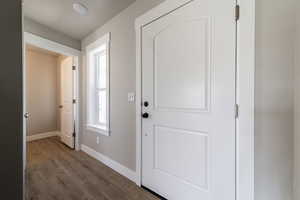 Foyer entrance with baseboards and dark wood-type flooring