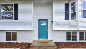 View of exterior entry featuring brick siding