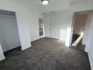 Unfurnished bedroom featuring dark colored carpet