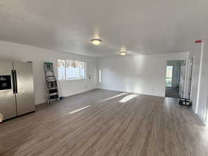 Unfurnished living room with a textured ceiling and wood finished floors