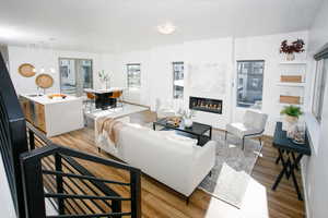 Living room with a glass covered fireplace and light wood finished floors