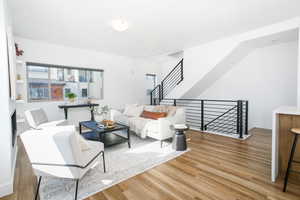 Living room featuring light wood-style flooring and stairs