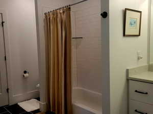 Bathroom with shower / tub combo with curtain, vanity, and tile patterned floors