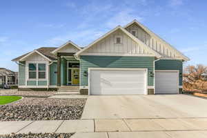 View of front of house with board and batten siding, concrete driveway, and a garage