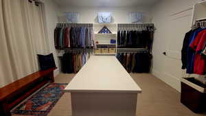 Walk in closet featuring light colored carpet