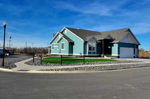 View of front of home featuring board and batten siding, an attached garage, concrete driveway, a shingled roof, and a front yard