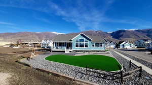 Back of house with a lawn, a mountain view, and a residential view