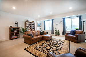 Living area with light colored carpet and recessed lighting