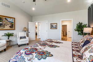 Bedroom with vaulted ceiling, light colored carpet, ceiling fan, and recessed lighting
