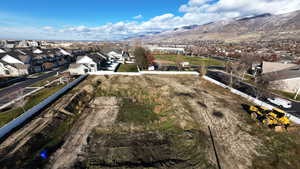 Aerial view of property and surrounding area featuring nearby suburban area and mountains