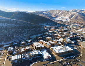 Aerial view of property and surrounding area featuring a mountainous background