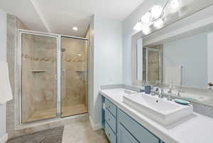 Full bathroom with vanity, light tile patterned floors, a shower stall, and recessed lighting