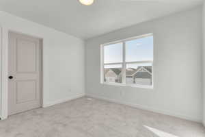 Unfurnished room with baseboards and light carpet