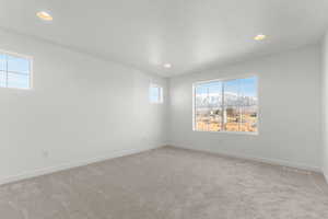 Carpeted empty room featuring recessed lighting and a mountain view