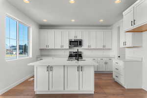 Kitchen with white cabinetry, recessed lighting, stainless steel appliances, and light wood-style flooring