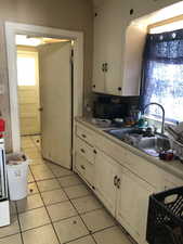 Kitchen with light countertops, plenty of natural light, black appliances, and light tile patterned floors