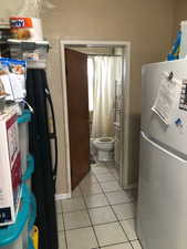Kitchen with freestanding refrigerator and light tile patterned floors
