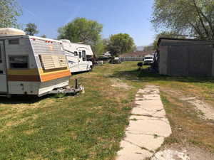 View of green lawn featuring an outbuilding
