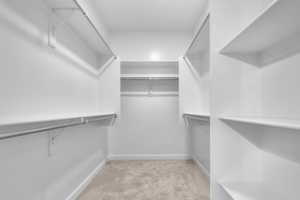 Walk in closet featuring light colored carpet