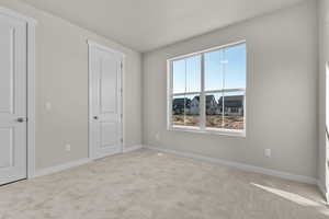 Unfurnished bedroom featuring carpet and baseboards