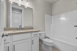 Bathroom with shower / bath combination, vanity, and light tile patterned floors
